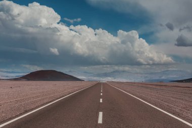 Kuzey Arjantin 'deki kumlu çöl ve çorak doğal manzaralarla dolu yüksek irtifada kirli bir yol..