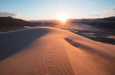 Kaliforniya, ABD 'deki kum tepeleri. Güzel doğa manzaraları gündoğumu arka planında seyahat eder