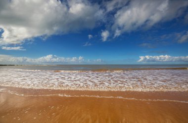 Kumda ayak izleri. Turkuaz suyu ve sarı kumsalı olan güzel bir sahil..