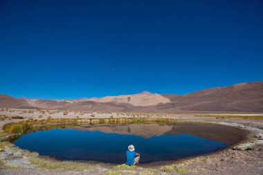 Bir adam sakin gölün yanında dinleniyor. Rahatlama tatili
