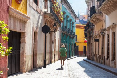 Meksika 'nın ünlü Guanajuato şehrindeki renkli caddede bir turist.