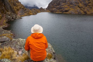 Bir adam sakin gölün yanında dinleniyor. Rahatlama tatili