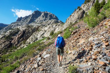 Sierra Nevada dağlarında yürüyen yürüyüş ekipmanlı bir adam, Kaliforniya, ABD