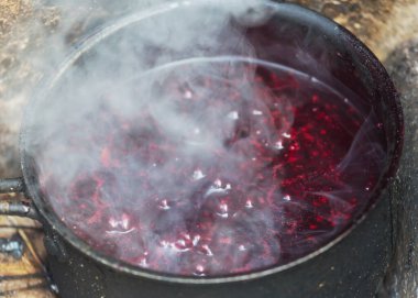 Yürüyüş sırasında kamp ateşinde yanan turistik çaydanlık. Ormanda odun üzerinde yemek pişirmek..