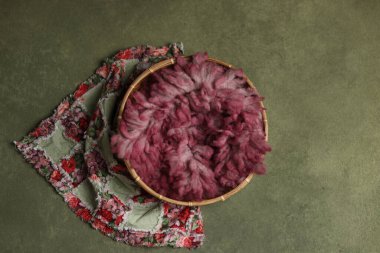 Yeni doğan fotoğrafçılık dijital arka plan desteği. Pembe kürklü hasır sepet ve boyalı bir tuval üzerinde çiçekler.