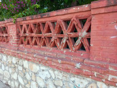 The old fence wall of vintage brick decorated