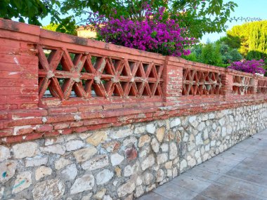 The old fence wall of vintage brick decorated