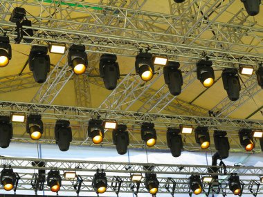 Spotlight devices in a row on  rigging steel trusses, installation of professional stage concert equipment.