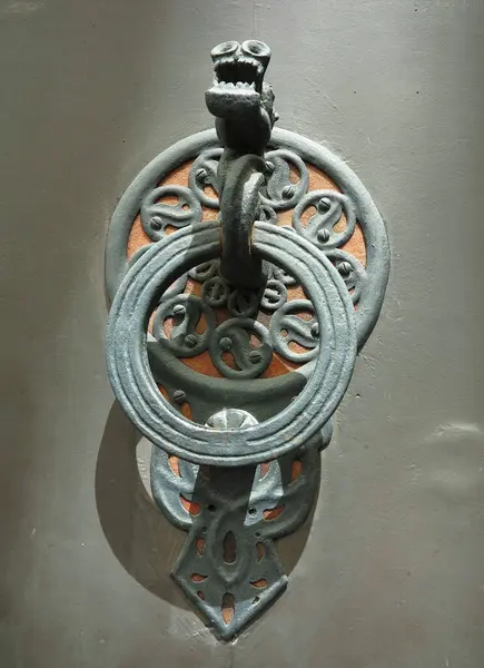 Beautiful bronze door handle with mythological dragon shape with wings on old vintage door