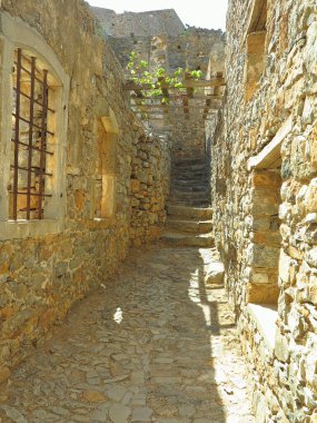 Eski cüzzamlı kolonisi Girit, Yunanistan 'daki Spinalonga Kalesi' nin duvar kalıntılarına bakın