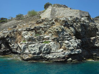 Eski cüzzamlı kolonisi Girit, Yunanistan 'daki Spinalonga Kalesi' nin duvar kalıntılarına bakın
