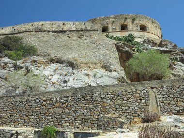 Eski cüzzamlı kolonisi Girit, Yunanistan 'daki Spinalonga Kalesi' nin duvar kalıntılarına bakın