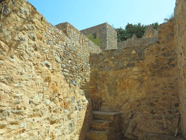 Eski cüzzamlı kolonisi Girit, Yunanistan 'daki Spinalonga Kalesi' nin duvar kalıntılarına bakın