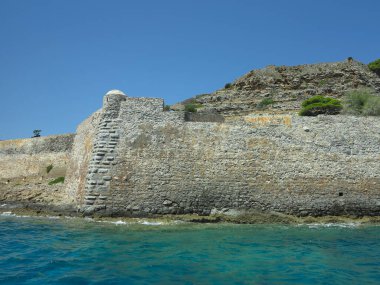 Eski cüzzamlı kolonisi Girit, Yunanistan 'daki Spinalonga Kalesi' nin duvar kalıntılarına bakın