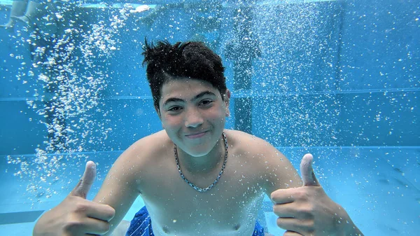 Glücklich Lächelnder Teenager Taucht Unter Wasser Und Zeigt Daumen Hoch Stockfoto