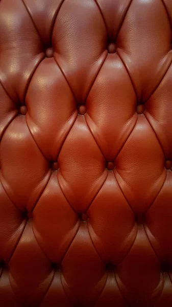 赤い革のソファとテクスチャ小さな背景ボタン ストック画像