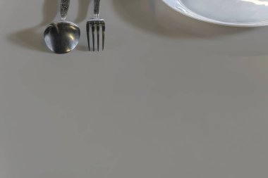 Çatal ve kaşık ve masada yemek tabağı.