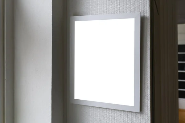リビングルームの壁にかかって写真のためのモックアップスペースと白い木製の画像フレーム 選択的な焦点 — ストック写真