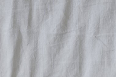 Yatak odasında arka plan olarak kırışık beyaz yatak çarşafları, üst görünüm