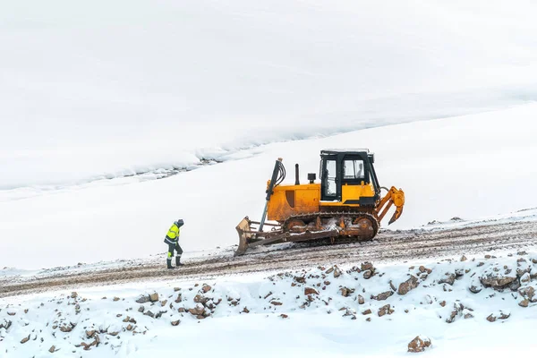 Kışın Inşaat Alanında Ağır Yapan Buldozer Önünde Sanayi Işçisi — Stok fotoğraf