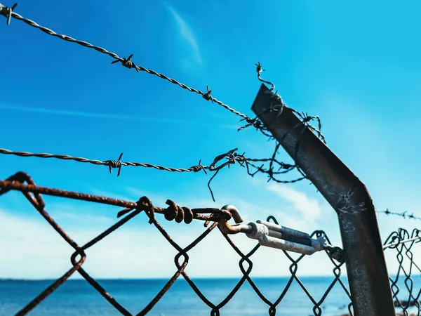 Ogrodzenie Drutu Kolczastego Przeciwko Błękitnemu Niebu Koncepcja Uwięzienia Niewoli Selektywne — Zdjęcie stockowe