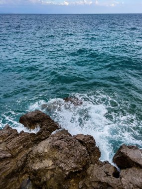 Waves breaking at rocky shoreline at Croatian beach
