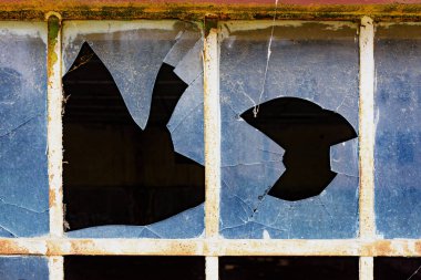 Broken dirty old glass of a grid window on vintage warehouse as background