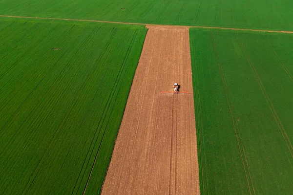 Aerial Shot Tractor Crop Sprayer Field Surrounded Green Wheat Plantation — Fotografia de Stock