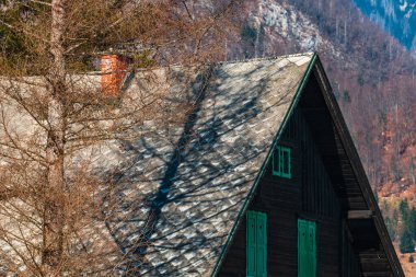 Güneşli kış gününde Triglav Ulusal Parkı 'nda geleneksel Sloven ahşap dağ evi