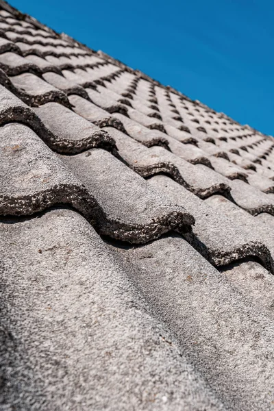 Concrete roof tiles with blue sky in background, selective focus