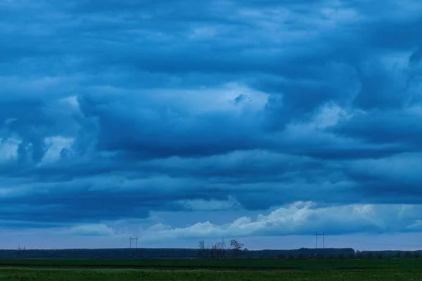 夕暮れ時の田園風景の上の空に激しい嵐の雲 雨の嵐と天候の変化が予想される — ストック写真