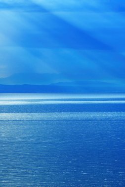 Morning sunlight beaming through clouds at Kvarner gulf of Adriatic sea in Croatia