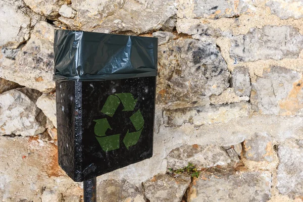 通りに緑のリサイクルのシンボルと黒のゴミ缶 コピースペースが含まれています — ストック写真