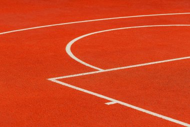 Beyaz çizgileri olan turuncu bir tartan basketbol sahasının minimalist soyut arka planı. Seçici odak.