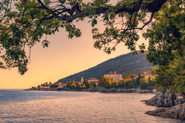 Lovran, Hırvatistan 'ın Adriyatik körfezinin Kvarner körfezindeki ünlü tatil beldesi. Gün batımında. Seçici odak.