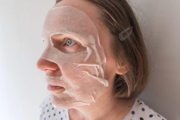 ヒアルロン酸を配合したシートフェイスマスクを使用した大人の白人女性 選択的フォーカス — ストック写真