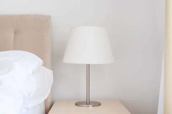 Yatak Odasındaki Komodinin Üzerinde Beyaz Gölgesi Olan Şık Bir Yatak — Stok fotoğraf