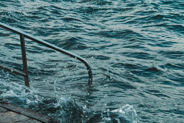 Havsvattenvågor Som Bryter Vid Strandlinjen Över Metallräcke — Stockfoto
