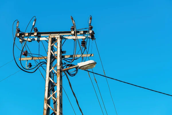 青い空に対してケーブルとワイヤと古い電力ユーティリティと街路灯ポール — ストック写真