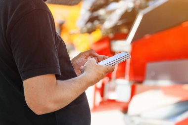 Yetişkin bir erkek cep telefonunda mesaj yazarken açık havada diğer telefonu altında tutarken, seçici bir odak noktası.