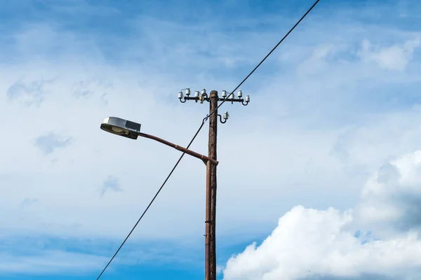 蓝天下的旧街灯和电线杆 — 图库照片