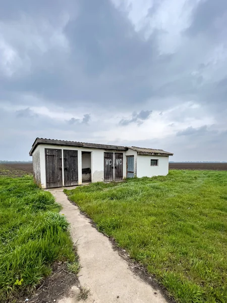 曇りの日に田舎の風景の中に古い屋外トイレの建物 — ストック写真