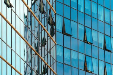 Mavi tonda cam cepheli modern kurumsal ofis binasının düşük açılı görüntüsü