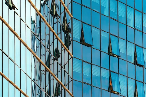 Mavi tonda cam cepheli modern kurumsal ofis binasının düşük açılı görüntüsü