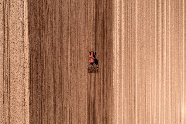 Červený Zemědělský Traktor Přiléhajícím Kormidlem Provádějící Orbu Pole Před Setím — Stock fotografie