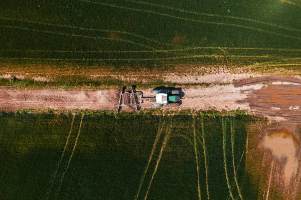 农业拖拉机的空中景观 带有舵柄的泥土路驶向田野 无人驾驶飞机的顶部景观 — 图库照片