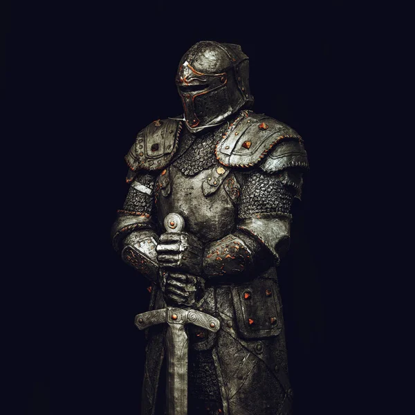 Statue of medieval knight in metal armor with a sword, isolated on dark black background, selective focus