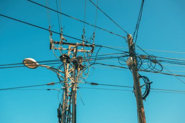 Elektrik direği ve elektrik kabloları olan sokak lambası, düşük açılı görüş.