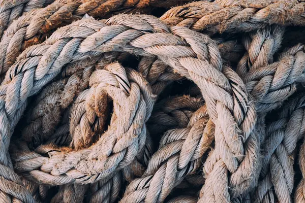 Old worn frayed ship ropes as background, selective focus