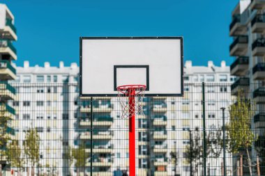 Konut bölgesinde asfalt yüzeyi olan açık hava basketbol sahası, seçici odaklı.